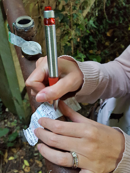 Signing the log book in a geocache